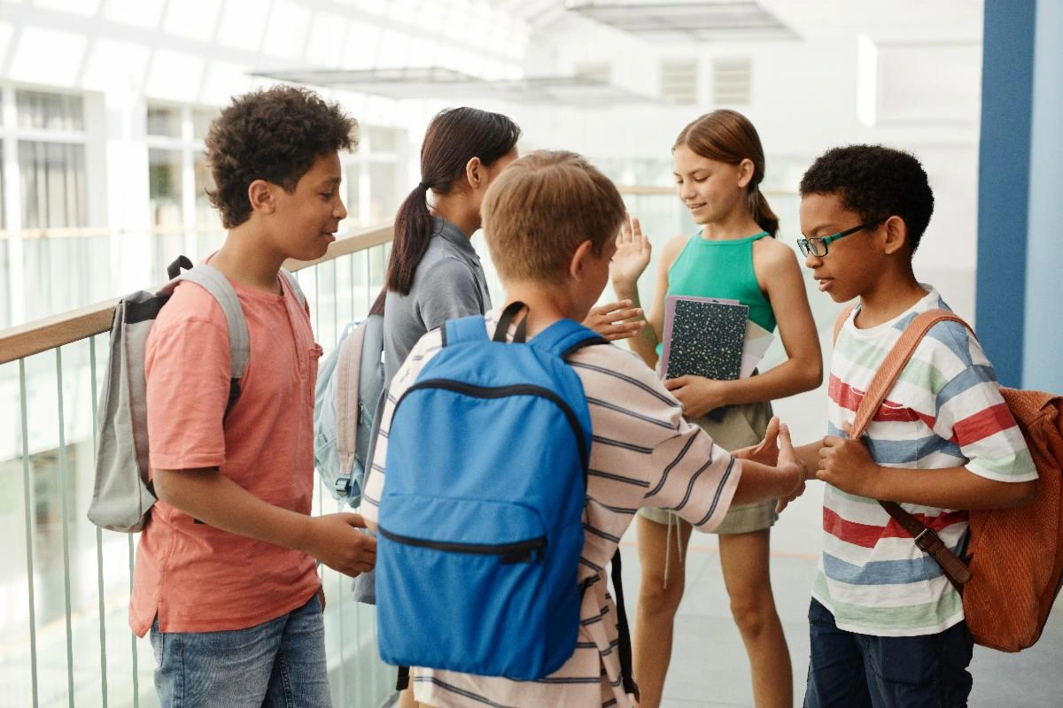 Students with backpacks talking together in a school hallway