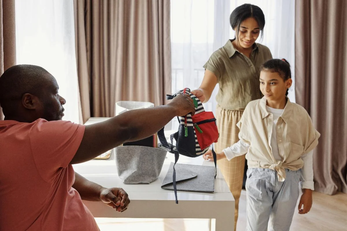 Family preparing for back-to-school with a child's backpack